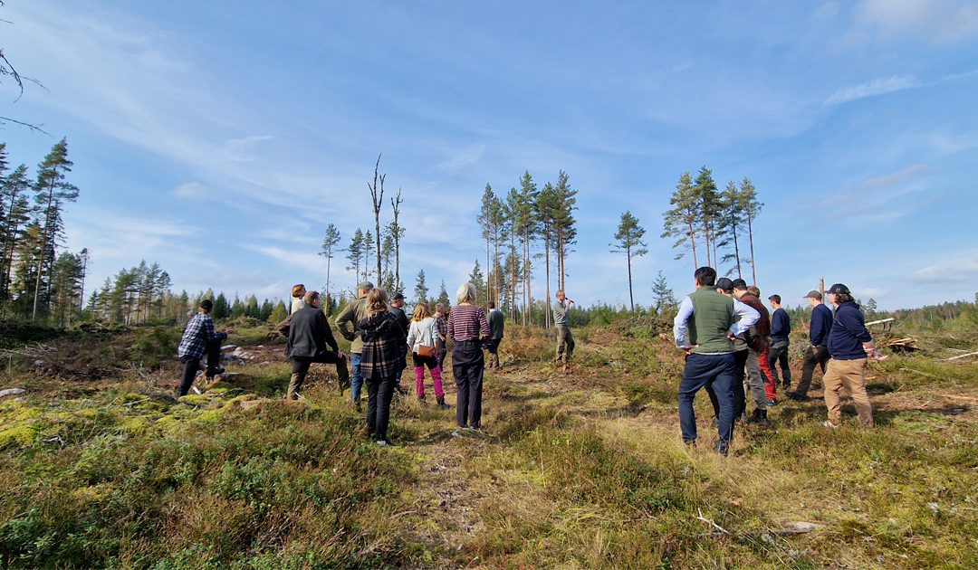 Metsäalueella seisoo ihmisiä keskustelemassa vesistönsuojelusta.